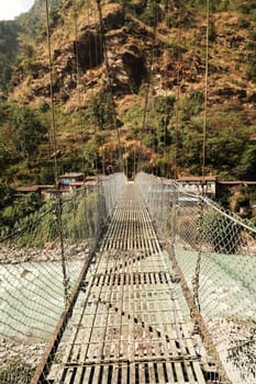 The metal suspension bridge over the Marsyangdi River leading into Syanche village, Annapurna Circuit Trek, Nepal 2022