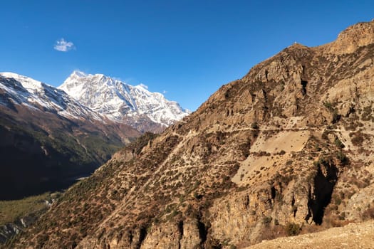 On the trail between Ghyaru and Manang, the snow capped peak of Annapurna III is rising in the background, Annapurna Circuit Trek, Nepal 2022