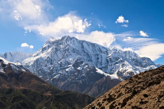 Spectacular view onto the snow capped peak of Annapurna III from the trail connecting Upper Pisang, Ghyaru village and Manang, Annapurna Circuit Trek, Nepal 2022