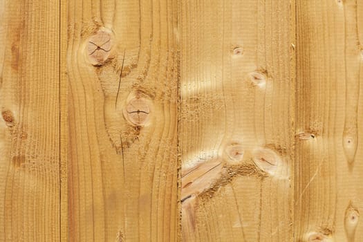 Light brown wooden wall on a construction fence with knotholes, Germany