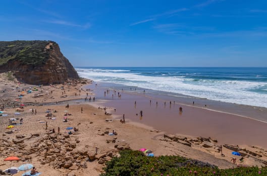 Sintra, Portugal: April 13, 2024: People at the beach of Sao Juliao, Mafra, Portugal