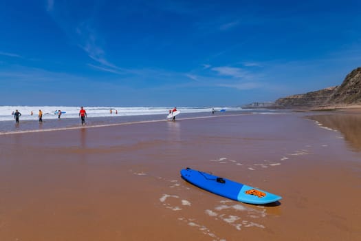 Ericeira, Portugal: April 13, 2024: Group of surfers with surfboards going to surfing. Ericeira is the famous surfing destination in Portugal.