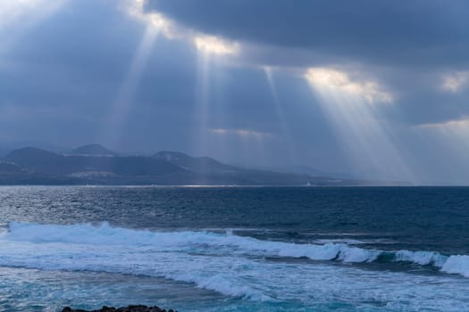 Beautiful sunrays on the Atlantic coast in Las Palmas de Gran Canaria, view from Las Canteras beach