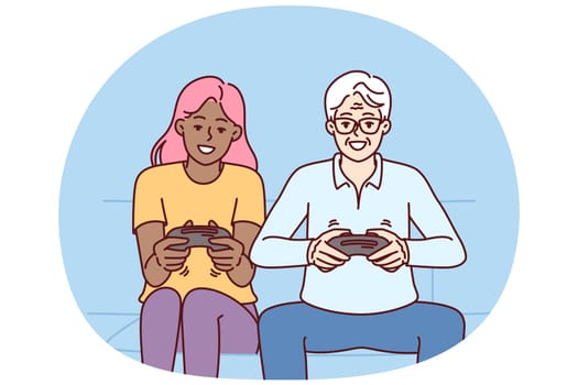 Diverse man and woman with joysticks are sitting on sofa playing game fighting virtual characters. Elderly human and African American girl play multiplayer console game spending weekend together