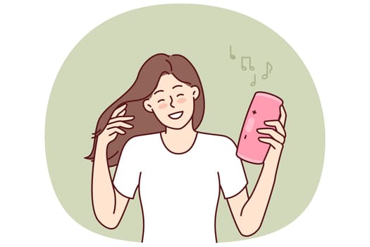Woman with wireless portable speaker smiling enjoying loud rhythmic music of favorite rock band. Young girl with pink portable speaker enjoys listening to playlist, creating disco atmosphere