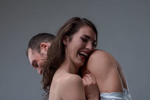 Young woman joyfully hugs a man, sharing a happy moment. Smiling and laughing, they show love and affection in a close embrace, radiating enjoyment and connection