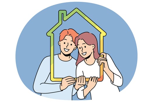 Man and woman with house outline symbolizing family property and sustainable energy efficient housing. Young couple recommends taking out mortgage or insuring house to avoid possible problems