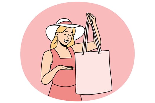 Woman holds textile bag recommending to refuse plastic disposable packages for shopping. Fashionable girl in hats demonstrates rag bag for comfortable visit to supermarket and care for nature.