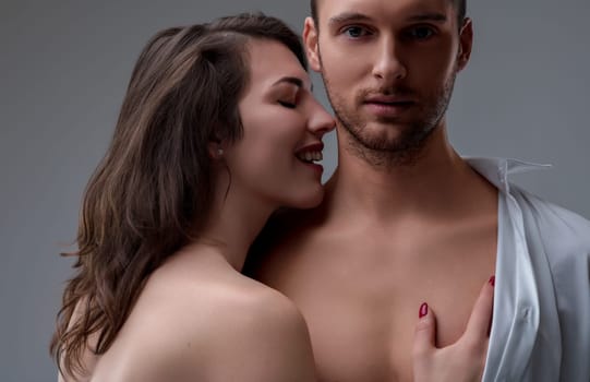 oman with dark hair and a seductive smile touches a man's chest, her red nails contrasting his bare skin. He tries to maintain composure, but his longing is evident