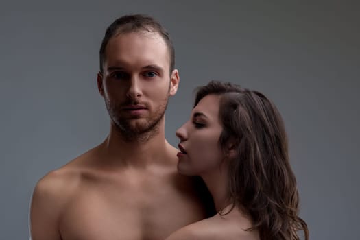 dark-haired woman embraces a man with confident desire, while he remains composed and contemplative. This image reflects modern gender dynamics and evolving perspectives on passion and relationships