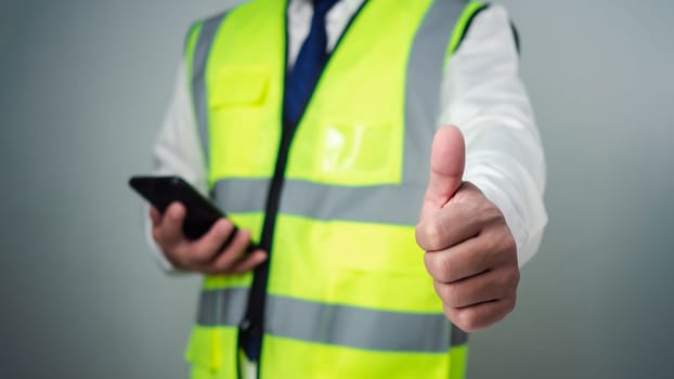 Thumbs up. Successful and happy architect standing against blurred background. Supporting construction designers to design building architecture. Architects or engineers supervise house construction.