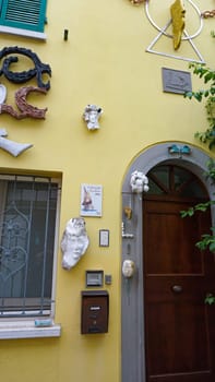 Rimini, Italy - June 25, 2024: Art installation on wall at Borgo San Giuliano typical street with low and colorful houses at Rimini, Italy