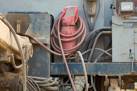 A heavy-duty hydraulic drill is hard at work on a construction site. Industrial background close up of digging machine.