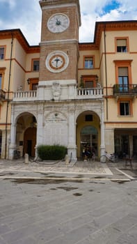 Rimini, Italy, September 2, 2021: People are passing a clock tower on the piazza martiri in the italian city rimini at Italy