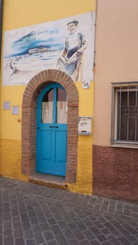Rimini, Italy - June 25, 2024: Mural on wall at Borgo San Giuliano typical street with low and colorful houses at Rimini, Italy