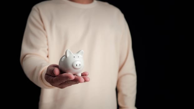 Businessman hand holding piggy bank, Save money and investment growth concept, Financial and business, Management money.