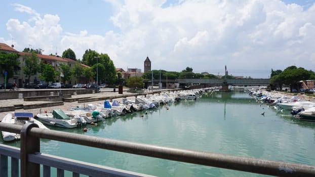 Rimini, Italy - June 25, 2024: Summer view of pier with ships, yachts and other boats with ferris wheel in Rimini, Italy.