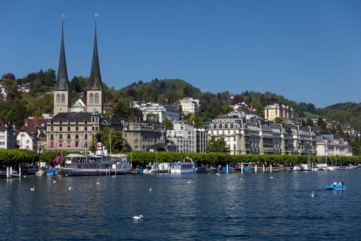The waterfront and the Hofkirche in the city of Lucerne (Luzurn) in Switzerland. The Hofkirche or Church of St. Leodegar, is a Roman Catholic church which dates from 1633.