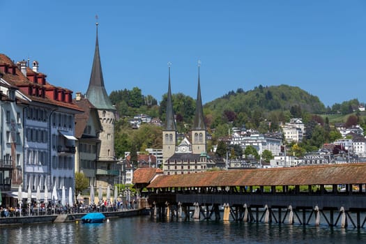 Chapel Bridge (Kapellbrucke) and the Hofkirche in the city of Lucerne (Luzurn) in Switzerland. The Hofkirche or Church of St. Leodegar, is a Roman Catholic church which dates from 1633.