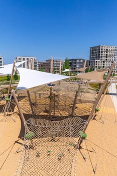 Large public city playground with slides and climbing frame, panorama of modern urban area