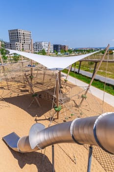 Large public city playground with slides and climbing frame, panorama of modern urban area