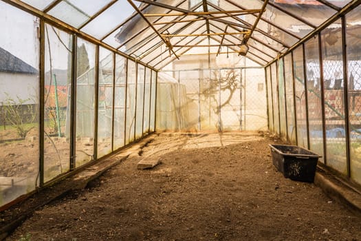 Inside of empty greenhouse, preparing soil in hothouse for sowing