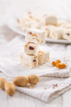 Soft nougat with peanuts on a plate, chewy sweets  with nuts