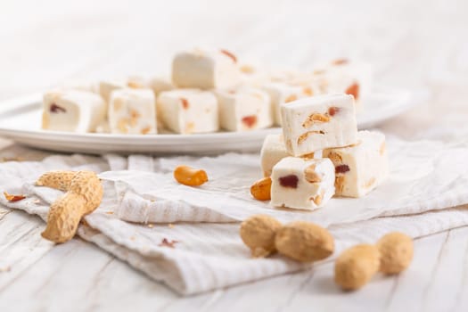 Soft nougat with peanuts on a plate, chewy sweets  with nuts