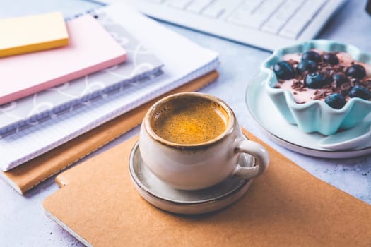 Coffee break in a office, cup of coffee with healthy yogurt in a office.  Workplace in a coffee shop or home office