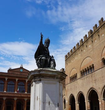 Rimini, Italy, September 2, 2021: Bronze statue of Pope Paolo V erected in 1614 on a marble pedestal, behind the pinecone fountain against the facade of 18th century fish market building