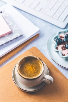 Coffee break in a office, cup of coffee with healthy yogurt in a office.  Workplace in a coffee shop or home office