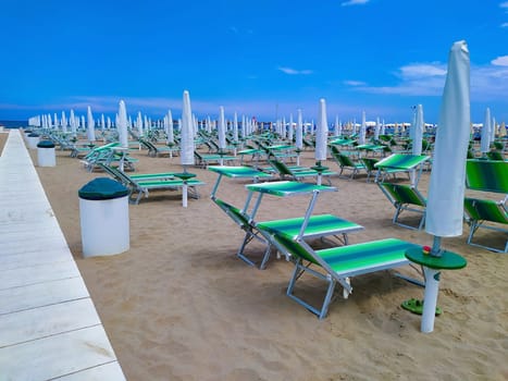 Summer. The sunbeds and parasols on the empty beach