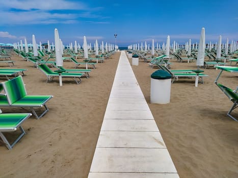 Summer. The sunbeds and parasols on the empty beach