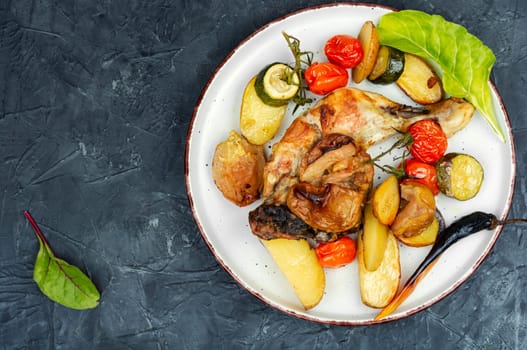 Juicy chicken meat baked with potatoes on a plate. Homemade chicken legs. Oven baked food