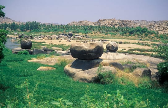 the Landscape and River with the typical Stones and Hills round of the town of Hampi in the Province of Karnataka in India.  India, Karnataka, March, 1998