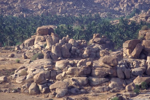 the Landscape with the typical Stones and Hills round of the town of Hampi in the Province of Karnataka in India.  India, Karnataka, March, 1998