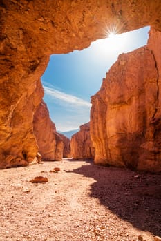 Sun peaking through the roof of the Natural Bridge rock formation in Death Vallley National Park in California