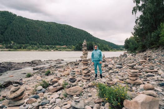 Man at the river Katun at summer day. Trip on Altai Mountains in Altai Republic