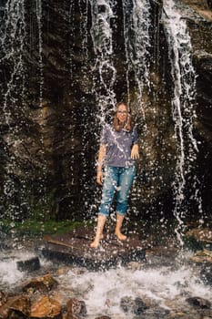 Woman at waterfall in summer Altai Mountains.