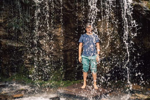 Man at waterfall in summer Altai Mountains.