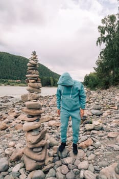Man at the river Katun at summer day. Trip on Altai Mountains in Altai Republic