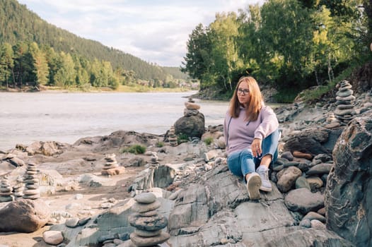 Woman at the river Katun at summer day. Trip on Altai Mountains in Altai Republic