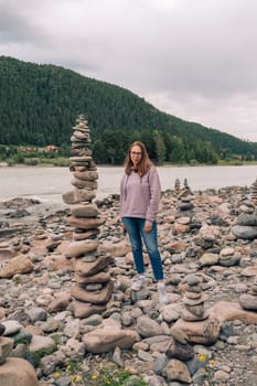 Woman at the river Katun at summer day. Trip on Altai Mountains in Altai Republic