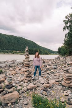 Woman at the river Katun at summer day. Trip on Altai Mountains in Altai Republic