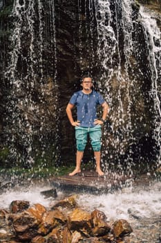 Man at waterfall in summer Altai Mountains.
