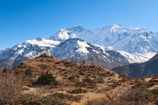 On the way up to the Ice Lake, view onto a buddhist stupa, pagoda in front of Annapurna II and IV, close to Manang, Annapurna Circuit Trek, Nepal 2022