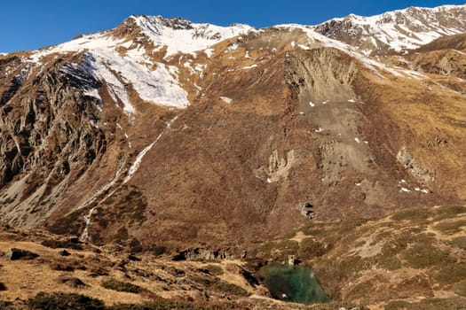 View onto ZivŽs Spring, a little mountain lake, pond of intense green, blue color between Yak Kharka, Ledar and Thorung, Thorong Phedi, Annapurna Circuit Trek, Nepal 2022