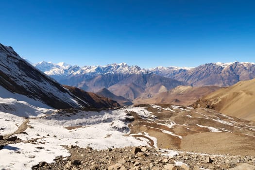 View from the trail from the Thorong La, Thorung La, Thorang La pass to Muktinath, a small ridge in front of a mountain range, Annapurna Circuit Trek, Nepal 2022