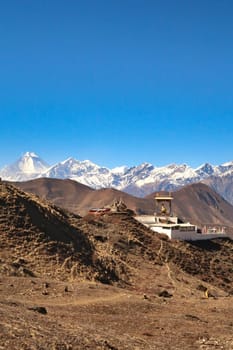 The Guru Rinpoche View Point in a hilly, dry landscape outside of the town of Muktinath in front of a snow capped mountain range with Dhaulagiri I on the left, Annapurna Circuit Trek, Nepal 2022