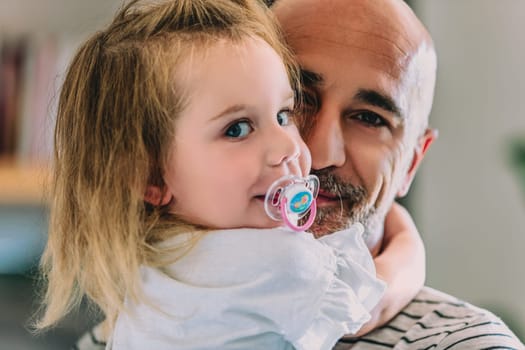 Joyful moment between a dad and his daughter, radiating love and happiness. The little girl's innocence captures a sweet family bond